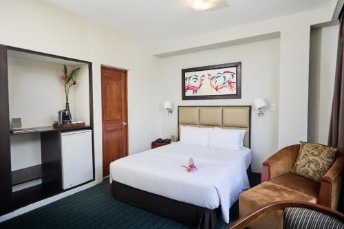 a hotel room with a bed and a chair at El Dorado Classic Hotel in Iquitos