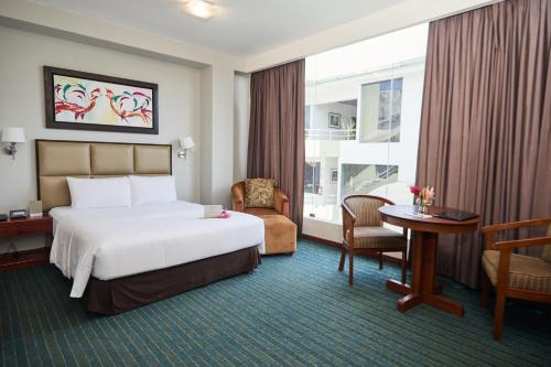 a hotel room with a bed and a desk and chair at El Dorado Classic Hotel in Iquitos