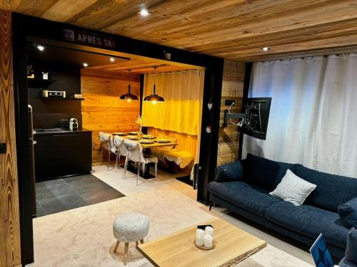 un salon avec un canapé bleu et une table dans l'établissement Appartement Chic et Cosy, à Aime La Plagne