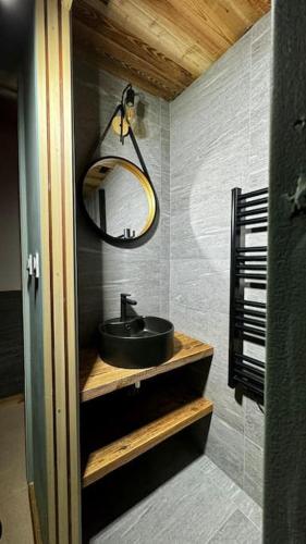 une salle de bain avec un lavabo et un miroir dans l'établissement Appartement Chic et Cosy, à Aime La Plagne
