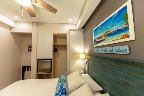 a bedroom with a bed and a tv on the wall at Casa Verano Beach Hotel - Adults Only in Santa Marta