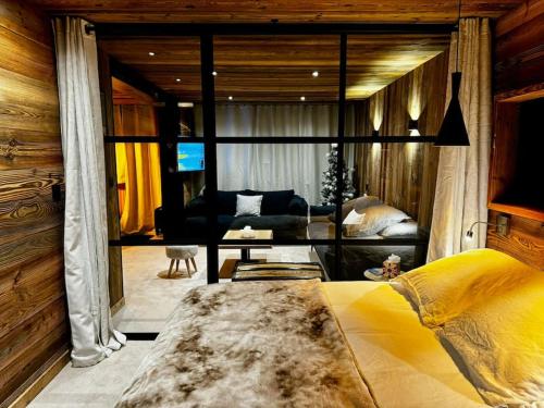 une chambre avec un grand lit et un salon dans l'établissement Appartement Chic et Cosy, à Aime La Plagne