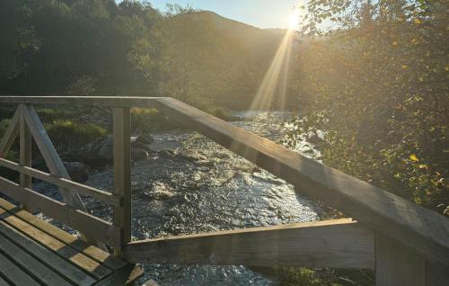 a wooden bridge over a river with the sun in the background at Lovely Home In Vikeså With Kitchen in Vikeså