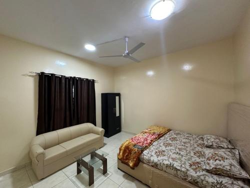 a bedroom with a bed and a ceiling fan at Elegant Master Suite with Luxurious Compfort in Ajman 