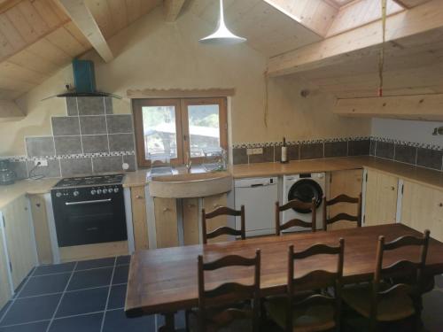 a kitchen with a wooden table and chairs in it at Gîte de ferme équestre in Auzet