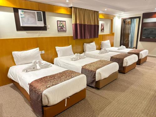 a hotel room with three beds and a tv at فندق ام جي كراون 3 - MG Crown Hotel 3 in Medina