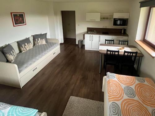 a room with a bed and a table and a kitchen at Penzion Bez Modrého Páva in Štramberk