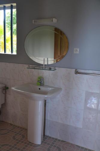 a bathroom with a white sink and a mirror at Hotel Nautile in Sainte Marie