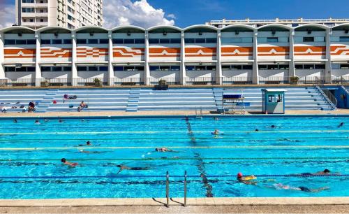 une grande piscine avec des gens qui nagent dedans dans l'établissement Charmant studio au cœur du Mourillon, à Toulon