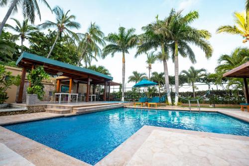a pool at a resort with palm trees at Casa Verano Beach Hotel - Adults Only in Santa Marta