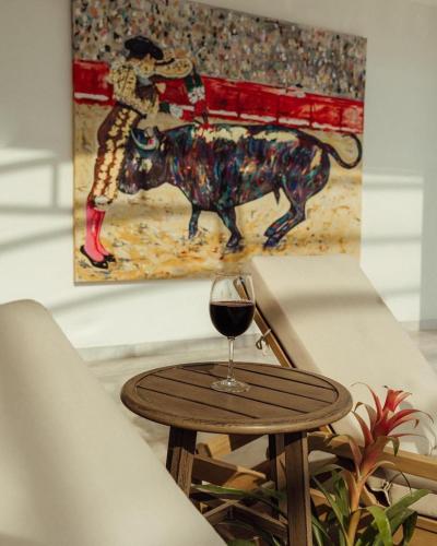 ein Glas Wein auf einem Tisch mit einem Stier in der Unterkunft Rosa y Oro Hotel Boutique in San Ignacio