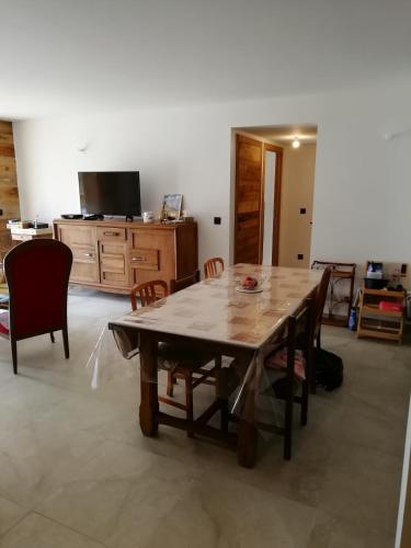 une salle à manger avec une table et des chaises en bois dans l'établissement L'oxalis appartement 103 Praz de Lys, à Praz de Lys - Sommand