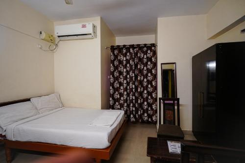 a small bedroom with a bed and a window at Hotel Golden Rooms in Tirupati