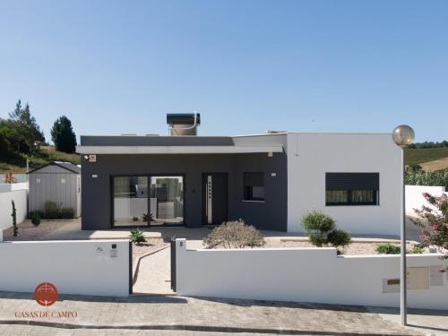 a white house with a fence in front of it at Casas de Campo - Vale da Terça in Vermelha