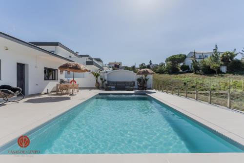 a villa with a swimming pool and a house at Casas de Campo - Vale da Terça in Vermelho