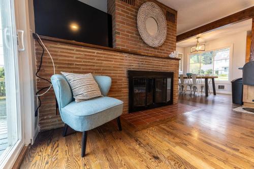 a living room with a chair and a brick fireplace at #StayinMyDistrict Garibaldi Bay Views in Garibaldi