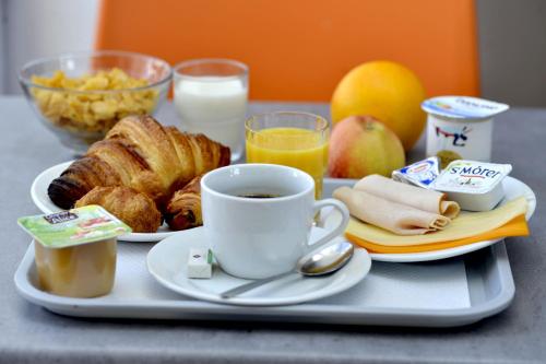 a tray with breakfast foods and a cup of coffee at KYRIAD ECO LILLE SUD - Noyelles Godault in Noyelles-Godault