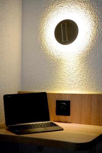 a laptop computer sitting on a desk under a light at KYRIAD ECO LILLE SUD - Noyelles Godault in Noyelles-Godault