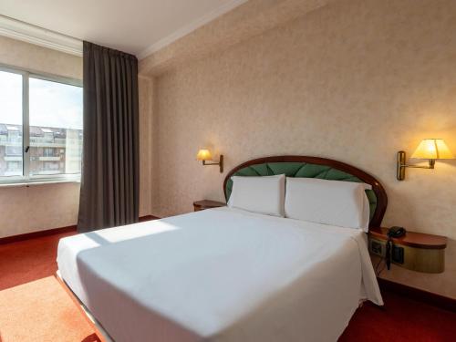 a large white bed in a room with a window at B&B Hotel Borgaro Torinese in Borgaro Torinese