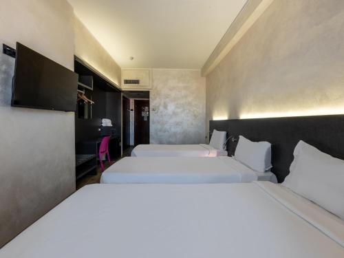a hotel room with two beds and a tv at B&B Hotel Borgaro Torinese in Borgaro Torinese