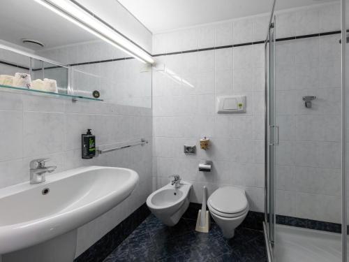 a white bathroom with a sink and a toilet at B&B Hotel Borgaro Torinese in Borgaro Torinese