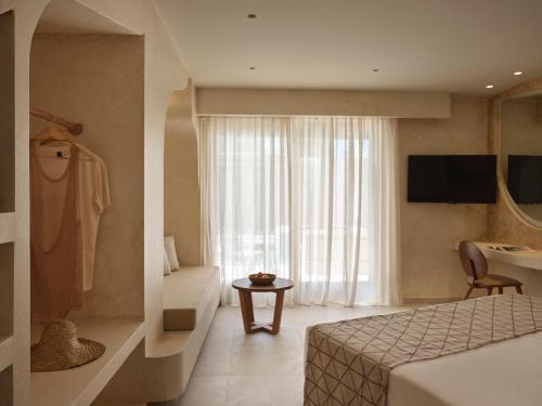 a hotel room with a bed and a window at Heyday Luxury Suites in Perissa