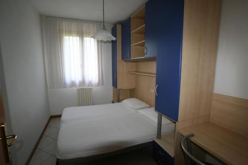 カヴァッリーノ・トレポルティにあるLe Briccoleのベッドと窓が備わる小さな客室です。