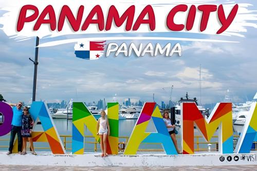 a group of people standing in front of a sign on the beach at Apartamento en San Francisco in Panama City