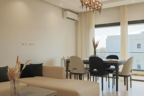 a living room with a table and chairs and a couch at Bright and Cozy New 3 Bedrooms Apartment in Tunis