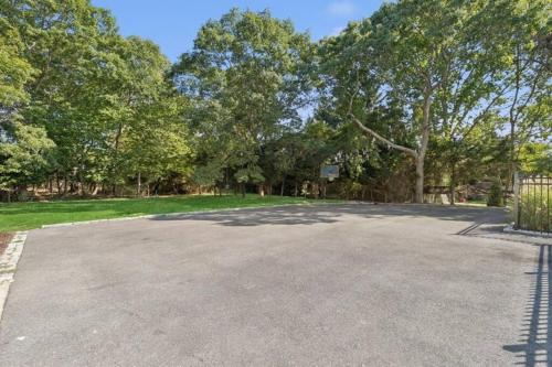 an empty parking lot with trees in the background at Beach Nirvana in Westhampton Beach