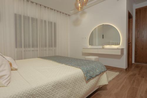 a white bedroom with a bed and a mirror at Bright and Cozy New 3 Bedrooms Apartment in Tunis