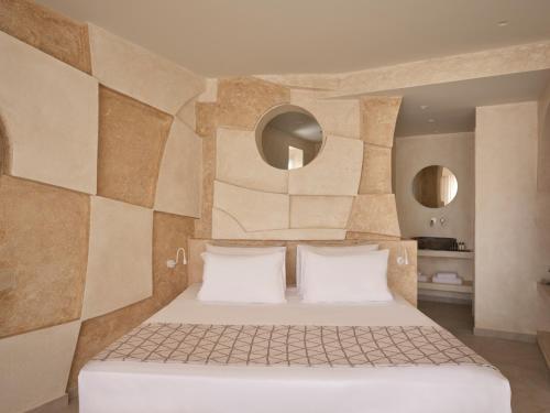 a bedroom with a large bed with white pillows at Heyday Luxury Suites in Perissa