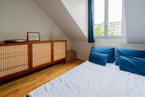 - une chambre avec un lit et des oreillers bleus dans l'établissement Modern Loft with Terrace in Paris, à Paris