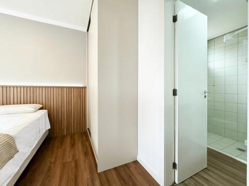 un dormitorio con una cama y una ducha en Apartamento no Jurerê Open Shopping - NDI007, en Florianópolis
