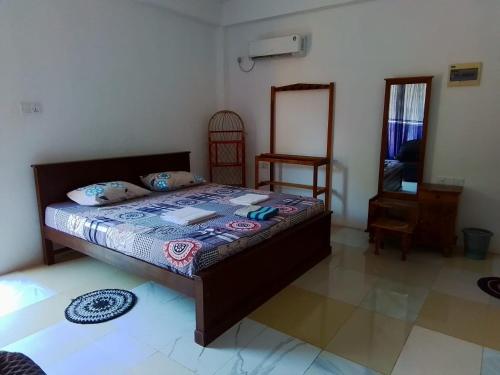 a bedroom with a bed and a mirror at Dolphin Village in Kalpitiya