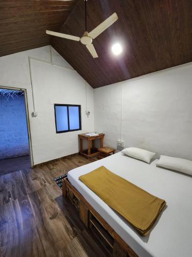 a bedroom with a bed and a ceiling fan at The Coco Leaf Cafe in Gokarna