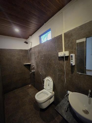 a bathroom with a toilet and a sink at The Coco Leaf Cafe in Gokarna