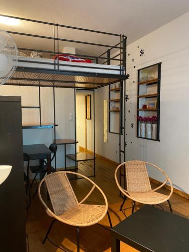 - 2 chaises et une table dans un dortoir avec des lits superposés dans l'établissement Big, à Narbonne