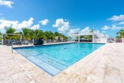 una piscina en un complejo con cielo azul en Spectacular Modern Key Largo Home, en Cayo Largo