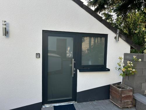 a black door on a white house with a window at Koblenzer Naturhaus & Apartments in Koblenz