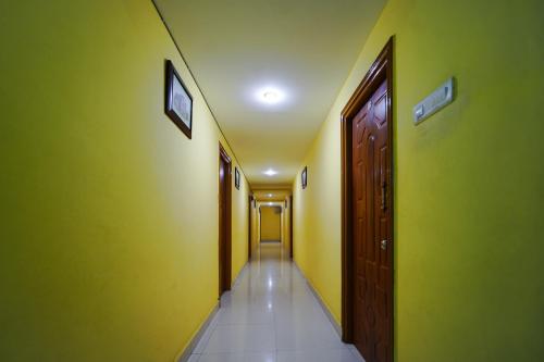 an empty hallway with yellow walls and brown doors at Hotel Golden Rooms in Tirupati