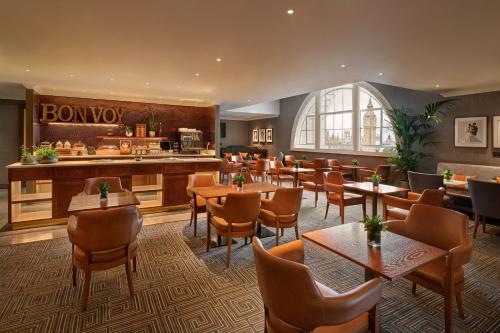 a restaurant with tables and chairs and a bar at London Marriott Hotel County Hall in London