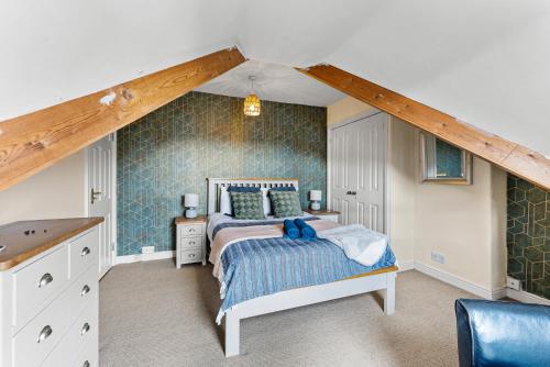 a bedroom with a bed with a blue wall at Stylish 6-BR home, Monthly Savings, Free Parking in Nether Edge