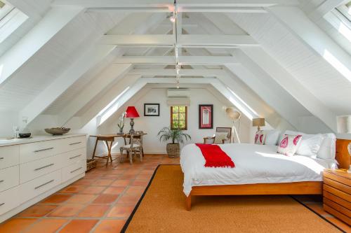 an attic bedroom with a bed and a desk at Franschhoek Manor Luxury Boutique Guesthouse in Franschhoek