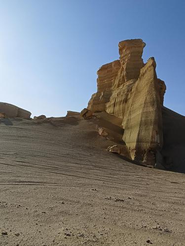 a rock formation in the middle of a desert at مخيمات وادى الريان بالفيوم in Qaryat Ḩātim aţ Ţāʼī