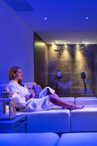 a woman sitting on a couch in a room at Tenuta Pilastru Country Resort & Spa in Arzachena