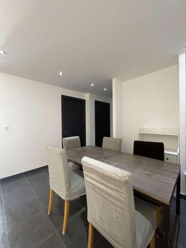 une salle à manger avec une table et des chaises en bois dans l'établissement Appartement neuf avec terrasse plein sud à Sainte-Maxime, à Sainte-Maxime