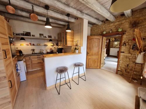 une cuisine avec un comptoir et deux tabourets au bar dans l'établissement Charmante chambre avec salle d'eau privative et espace salon - FR-1-584-325, à Boismont