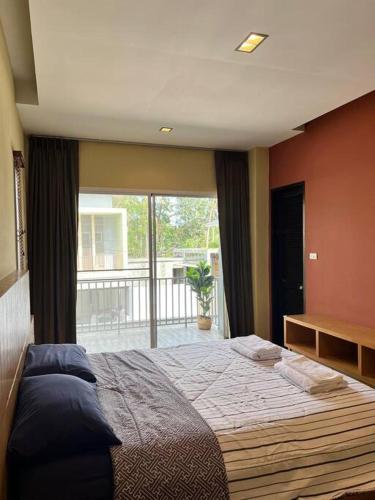 a bedroom with a large bed and a large window at Comfy townhouse at best location in Bangrak Beach