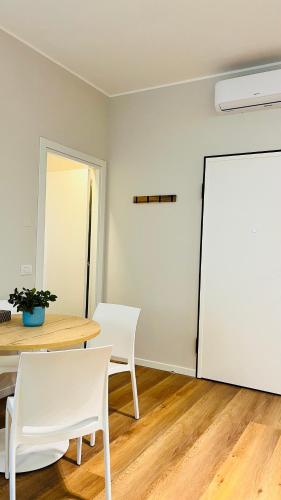 a room with a table and chairs and a white refrigerator at Leila's home forever - casa vacanze in Bergamo